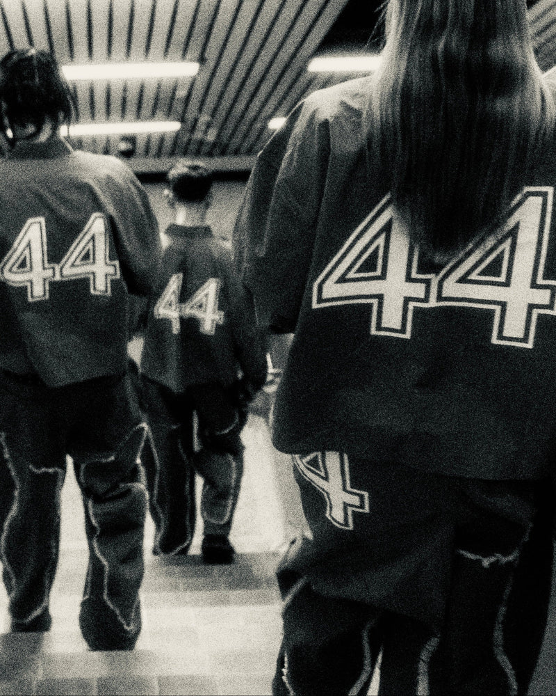 People wearing jackets with the number 44 in a monochrome setting