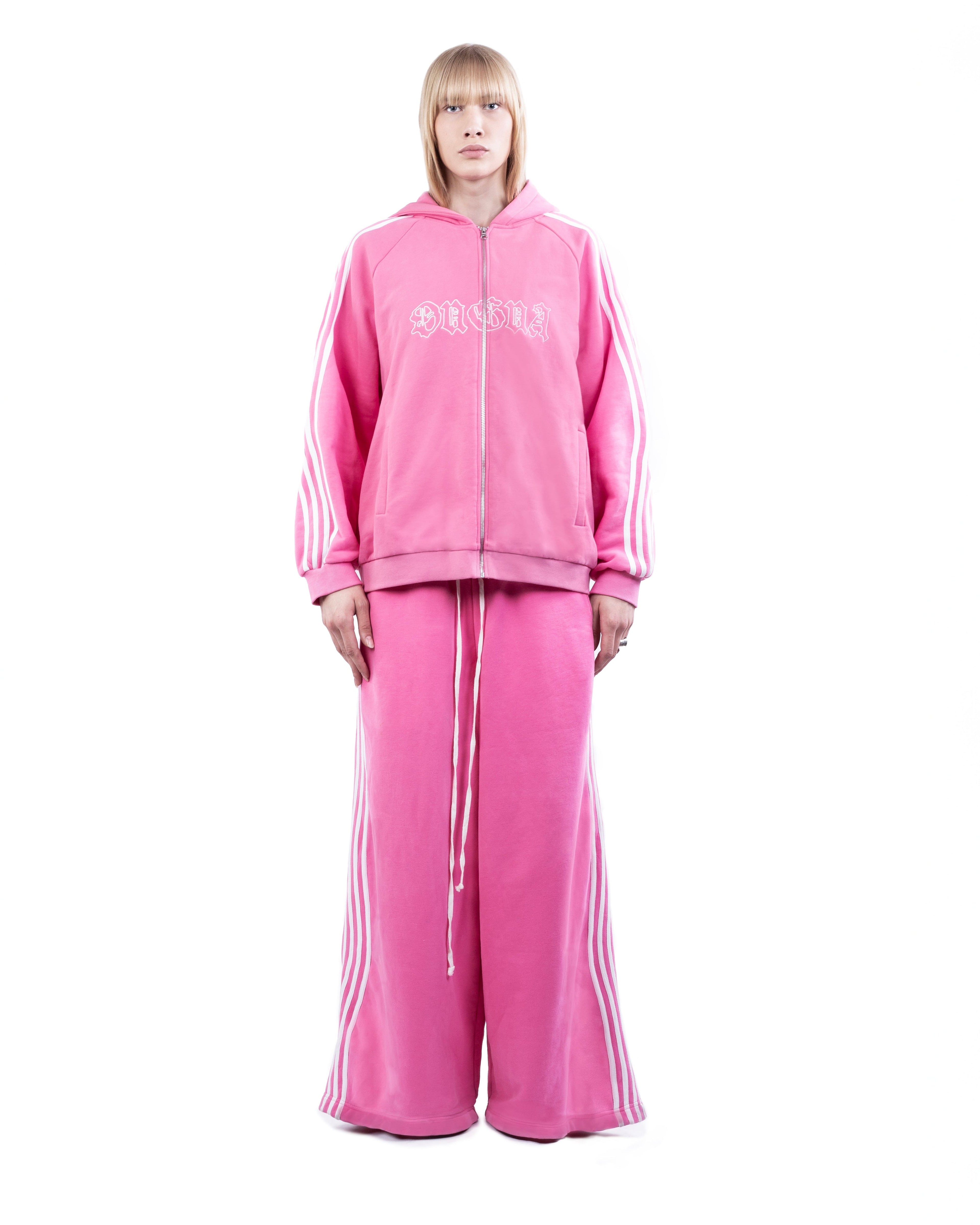 Person wearing a pink tracksuit with brand logo on a white background