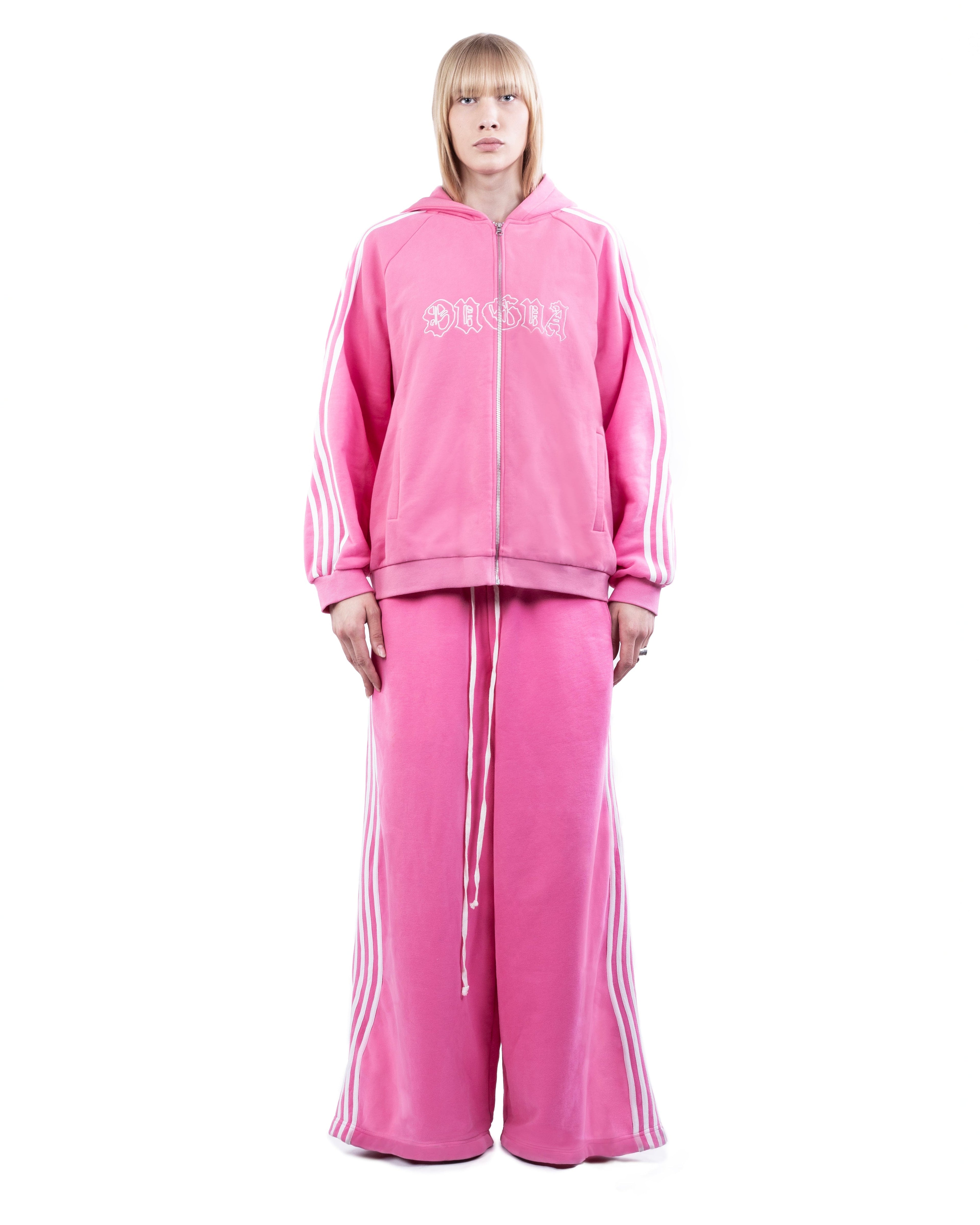 Person wearing a pink tracksuit with brand logo on a white background