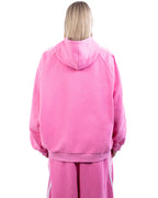 Person wearing a pink hoodie and pants on a white background