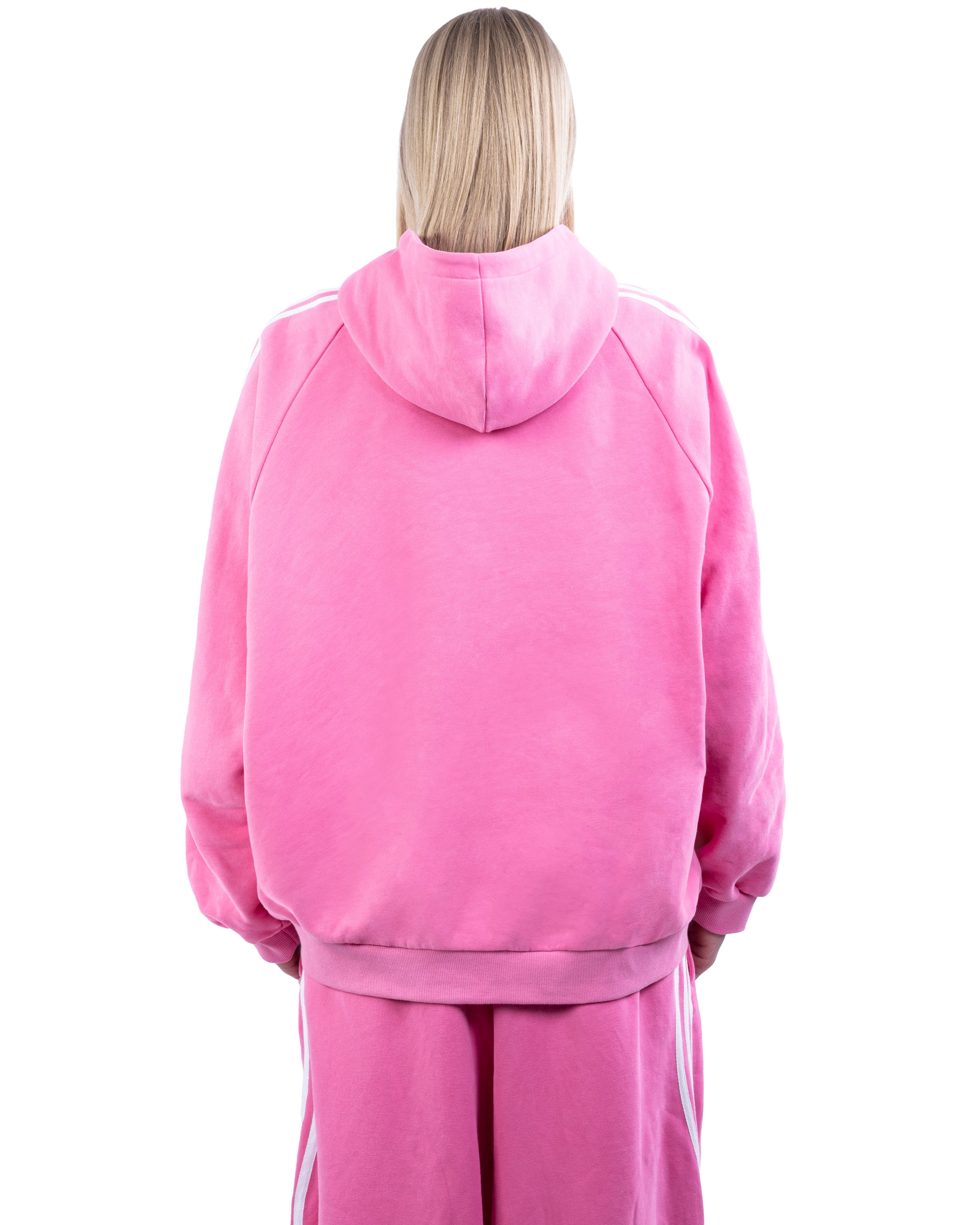 Person wearing a pink hoodie and pants on a white background
