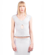 Woman wearing a light gray sleeveless top with a cutout design on a white background