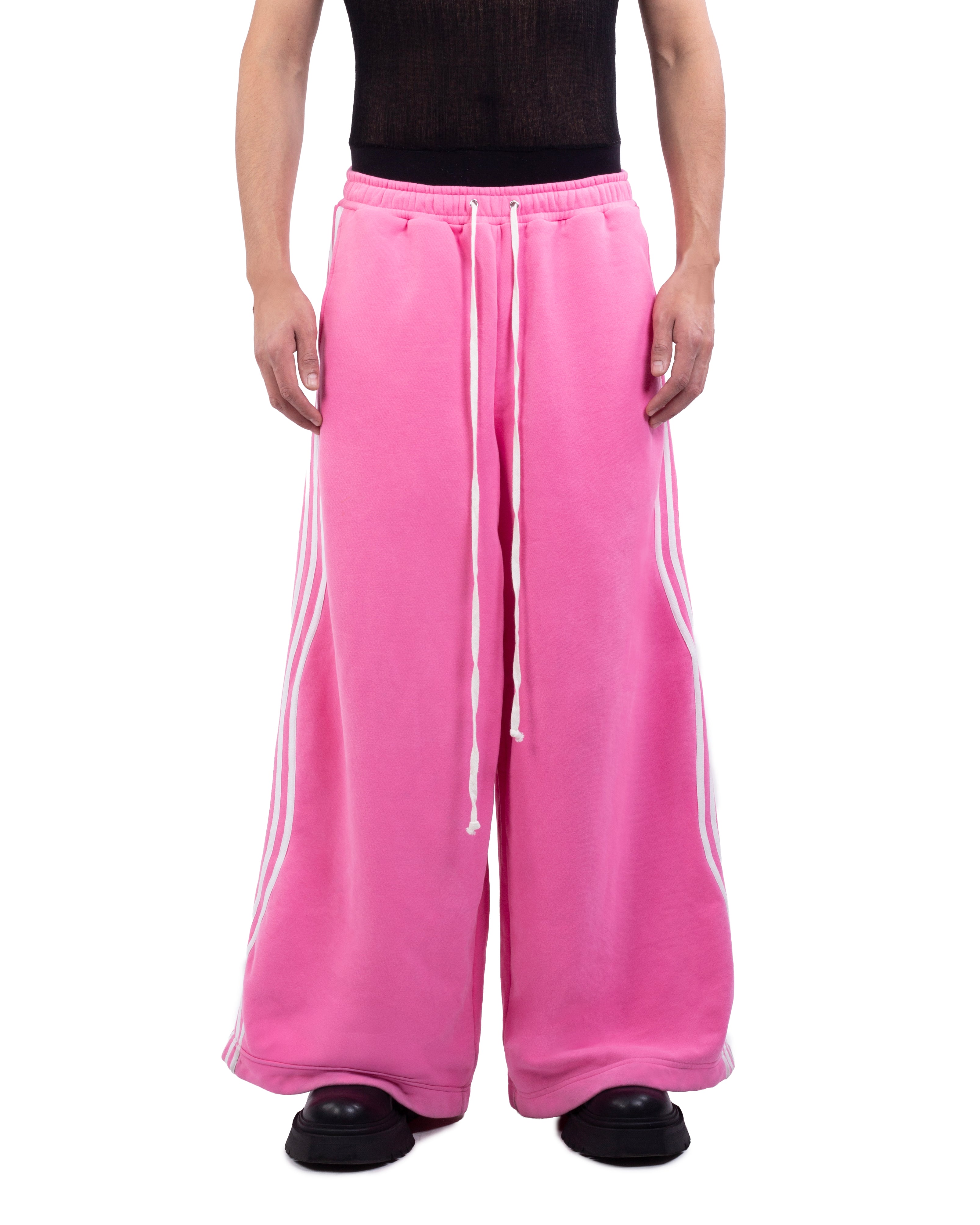 Pink sweatpants with white stripes worn by a person on a white background