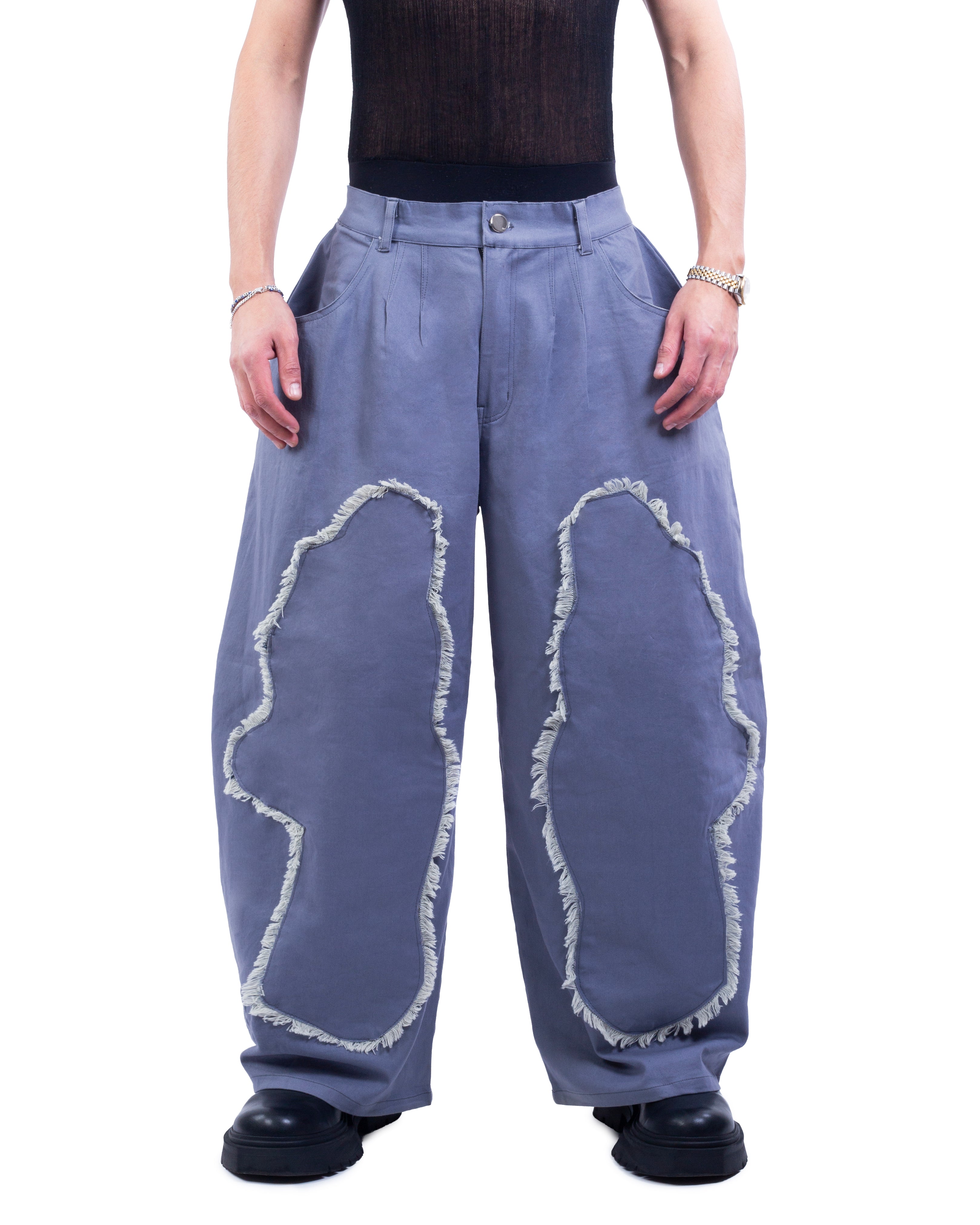 Person wearing blue pants with white distressed designs on a white background