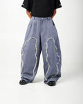 Model wearing AABELI denim pants with tassel detailing and pleats at the front and back, and GOMD Tee with a logo on the left sleeve.