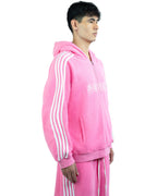 Person wearing a pink tracksuit with white stripes on a white background