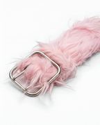 A close-up of a fluffy light pink faux fur belt with a silver metal buckle, set against a plain white background.