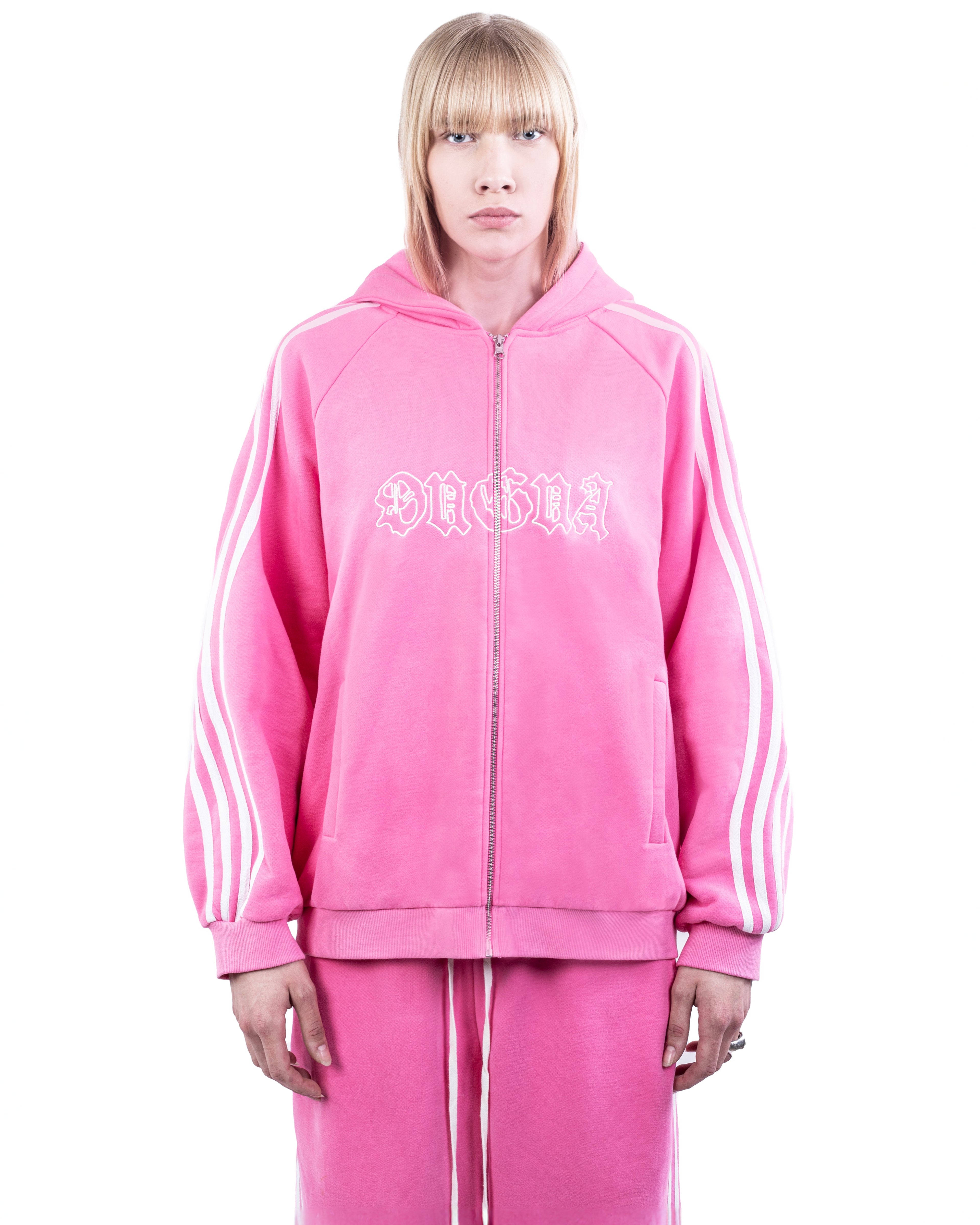 Person wearing a pink tracksuit with white stripes on a white background